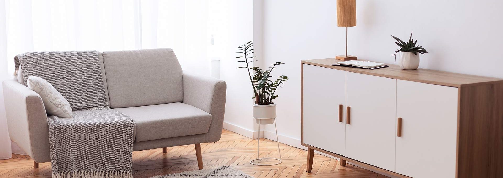 a living room with a white couch and a rug at The Cedars Apartments