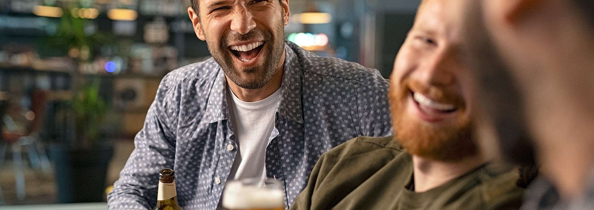 three men laughing and drinking beer at The Cedars Apartments